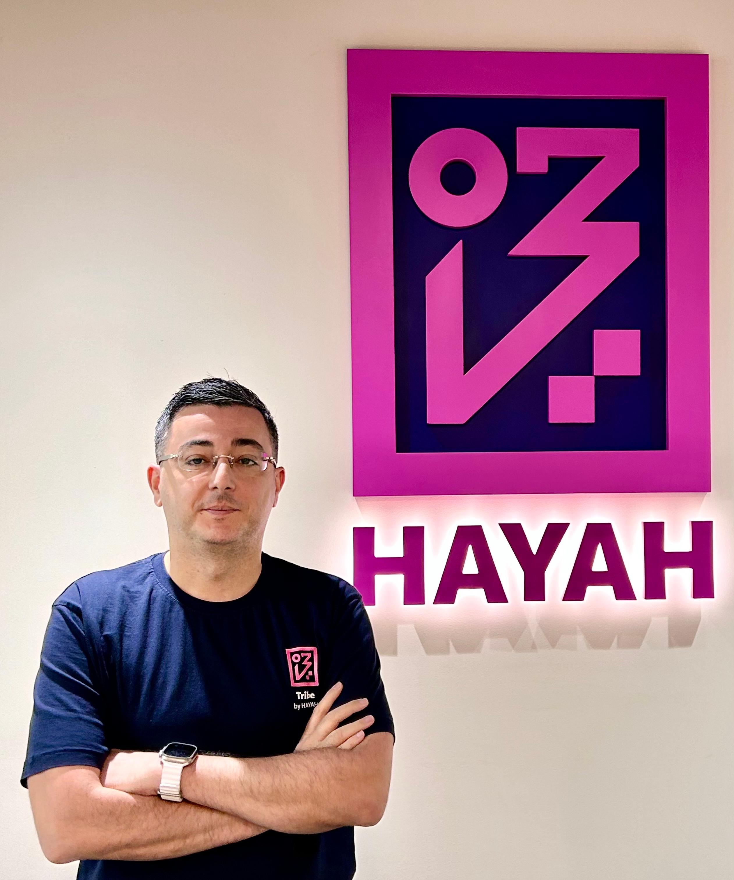 man standing next to hayah logo